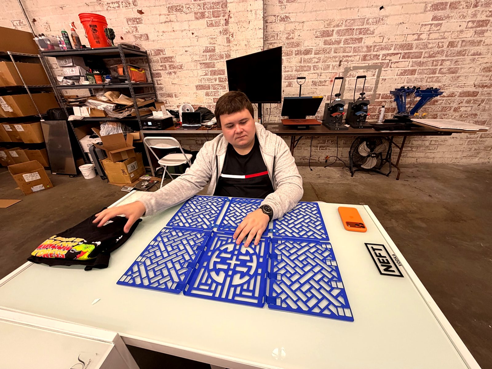 A participant setting up printing screens on the production table
